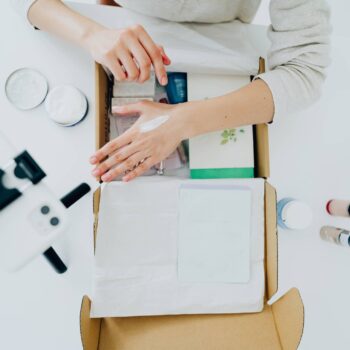 High angle view of a blogger unboxing and trying out skincare products in her studio; live streaming and giving first impressions on products.